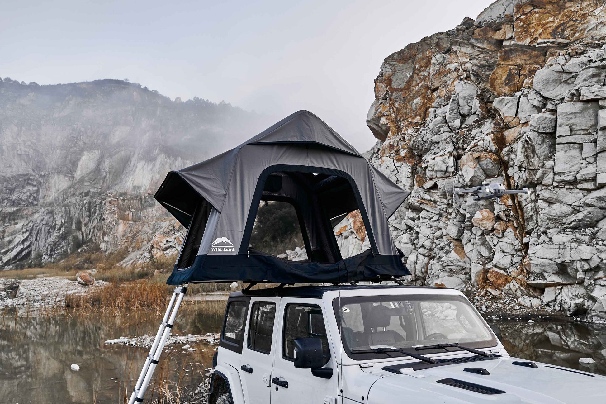 Aufgebautes aufblasbares Zweipersonen-Dachzelt auf einem Auto, seitliche Ansicht in den Bergen