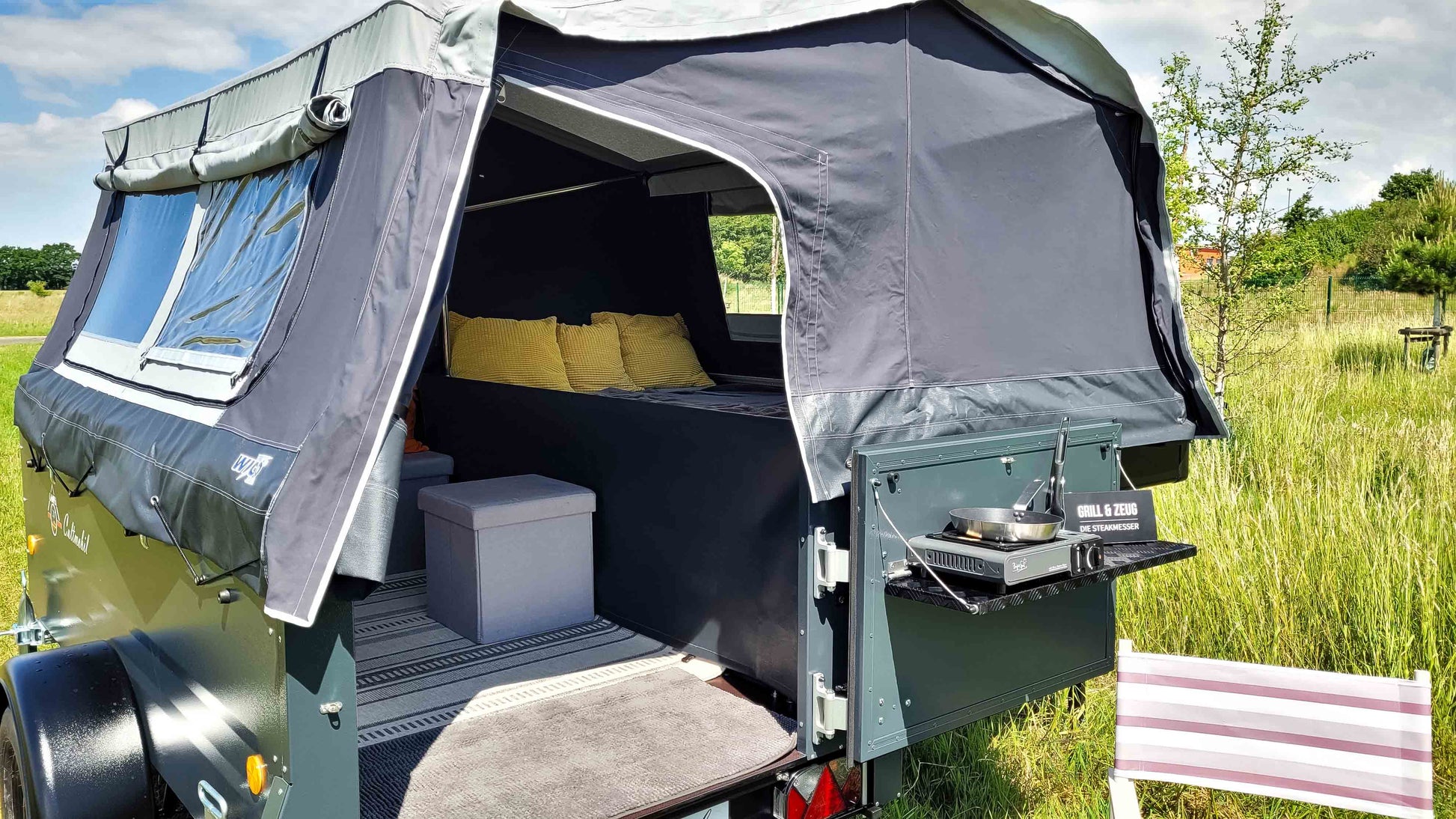 Zeltanhänger mit Blick in den Eingang auf einer Wiese