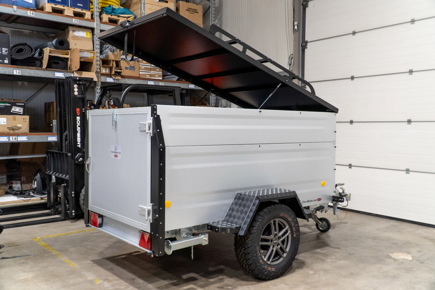 Ein silberner Offroad Anhänger in einer Lagerhalle