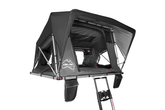 Aufgebautes Stoff-Dachzelt vor weißem Hintergrund, seitlich fotografiert.