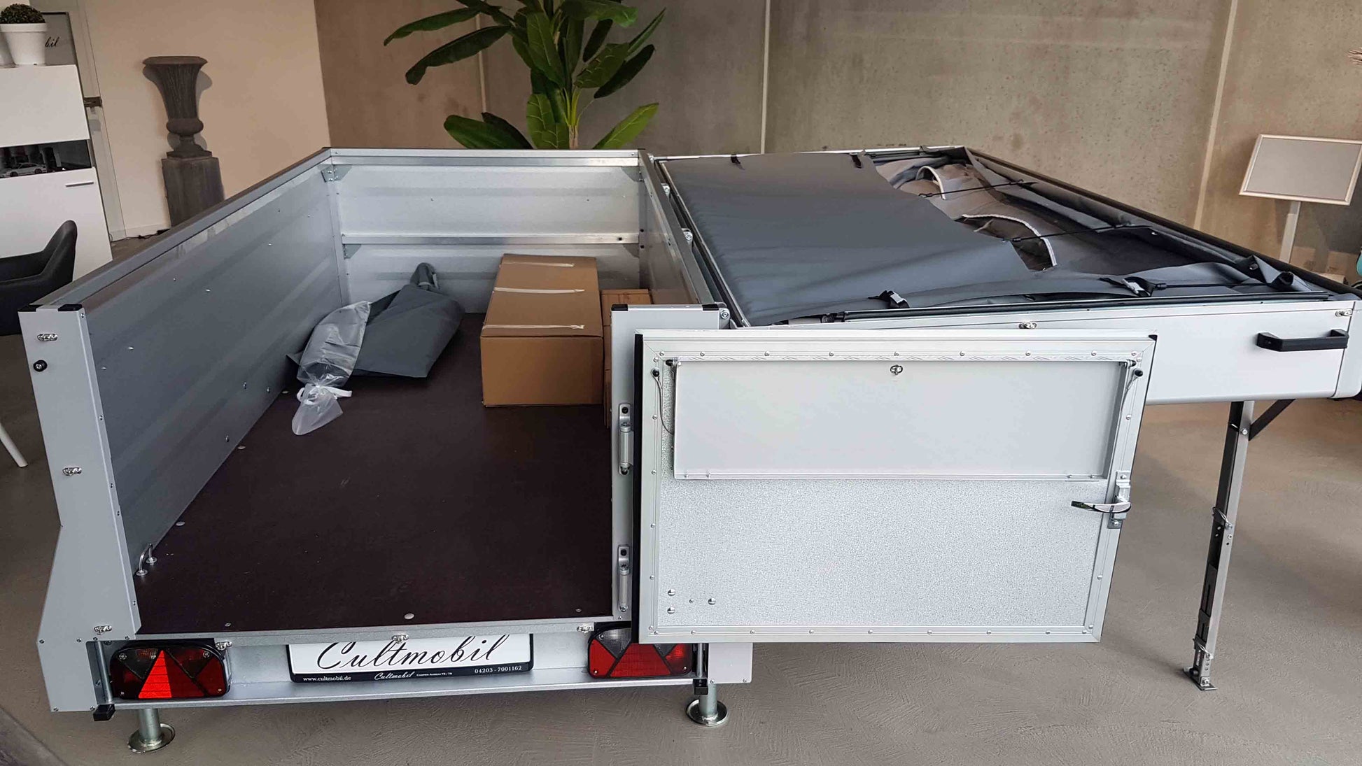 Campinganhänger mit umgeklapptem Deckel mit sichtbarem Stauraum