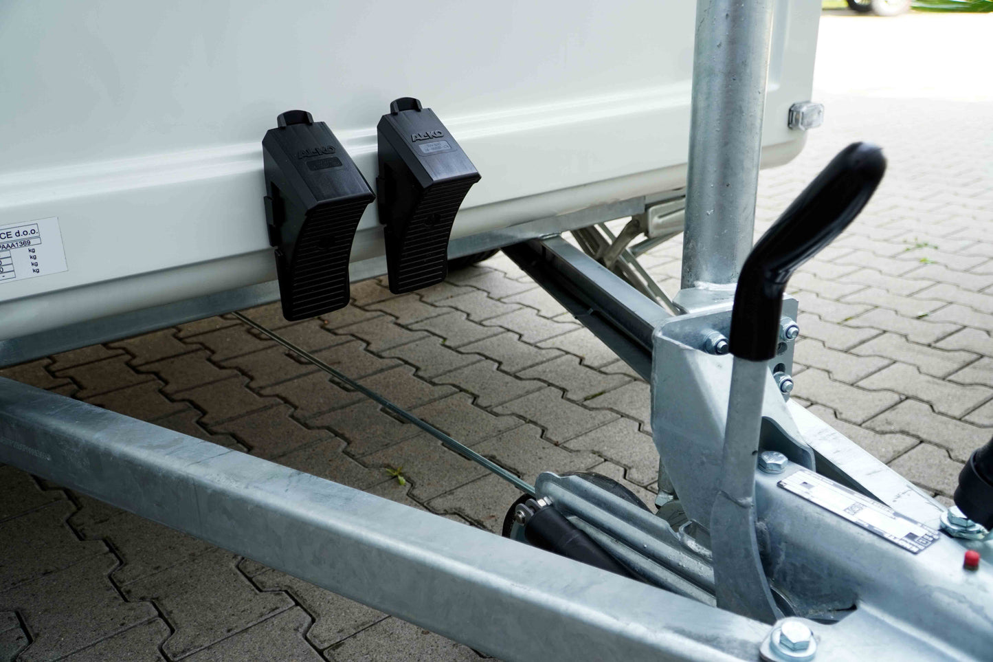 Die Auflaufbremse eines Verkaufsanhängers mit Reifenkeilen. 