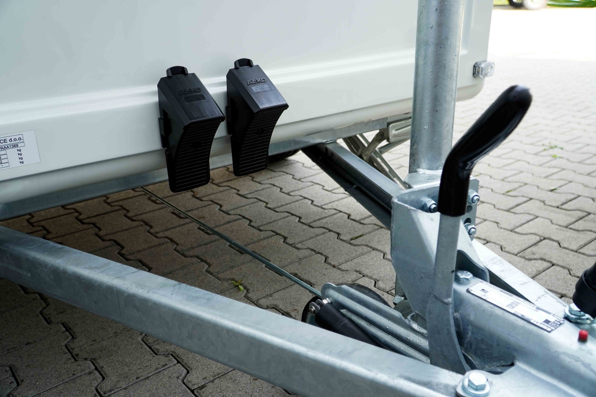 Die Auflaufbremse eines Verkaufsanhängers mit Reifenkeilen. 