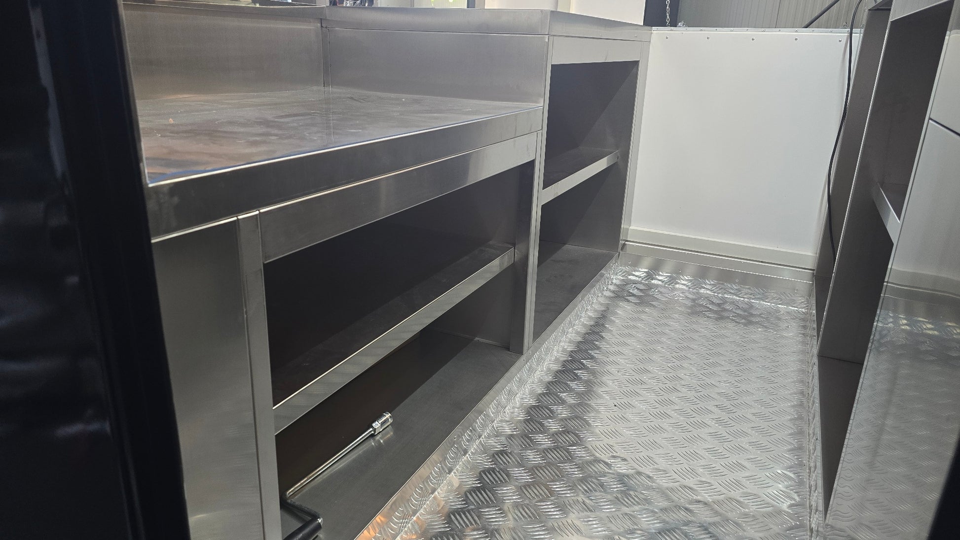 Innenansicht eines Foodtrailers mit Einrichtung, Arbeitsflächen und Schränken mit Verstaumöglichkeiten und einem Boden aus Alu Riffelblech