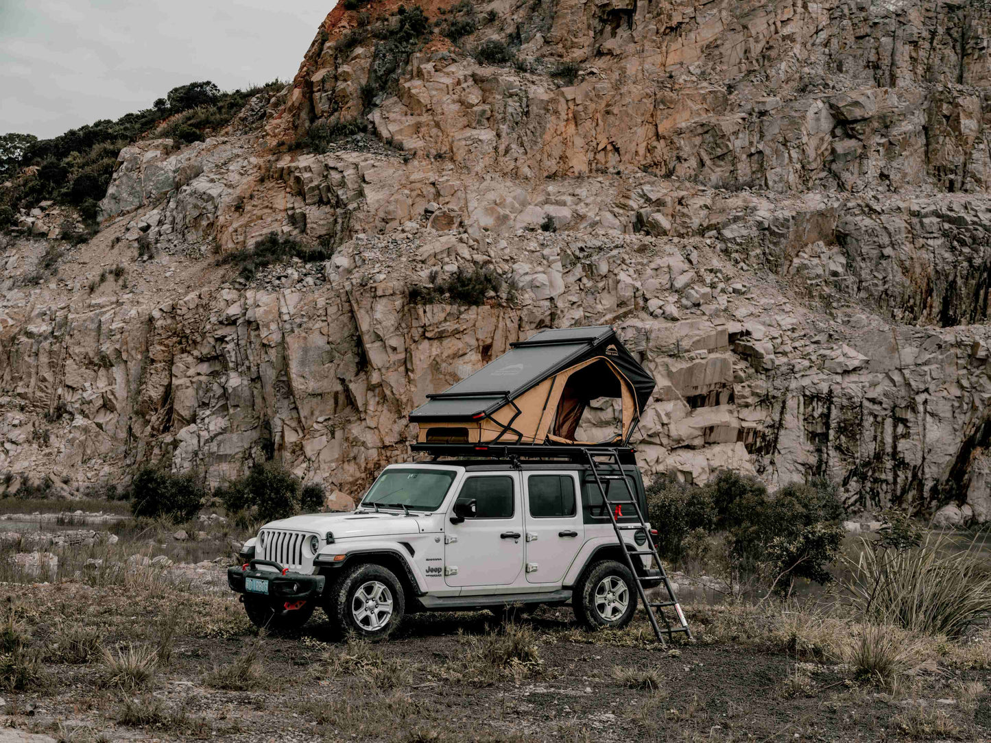 Ein auf dem Jeep aufgebautes Dachzelt vor einer Felswand