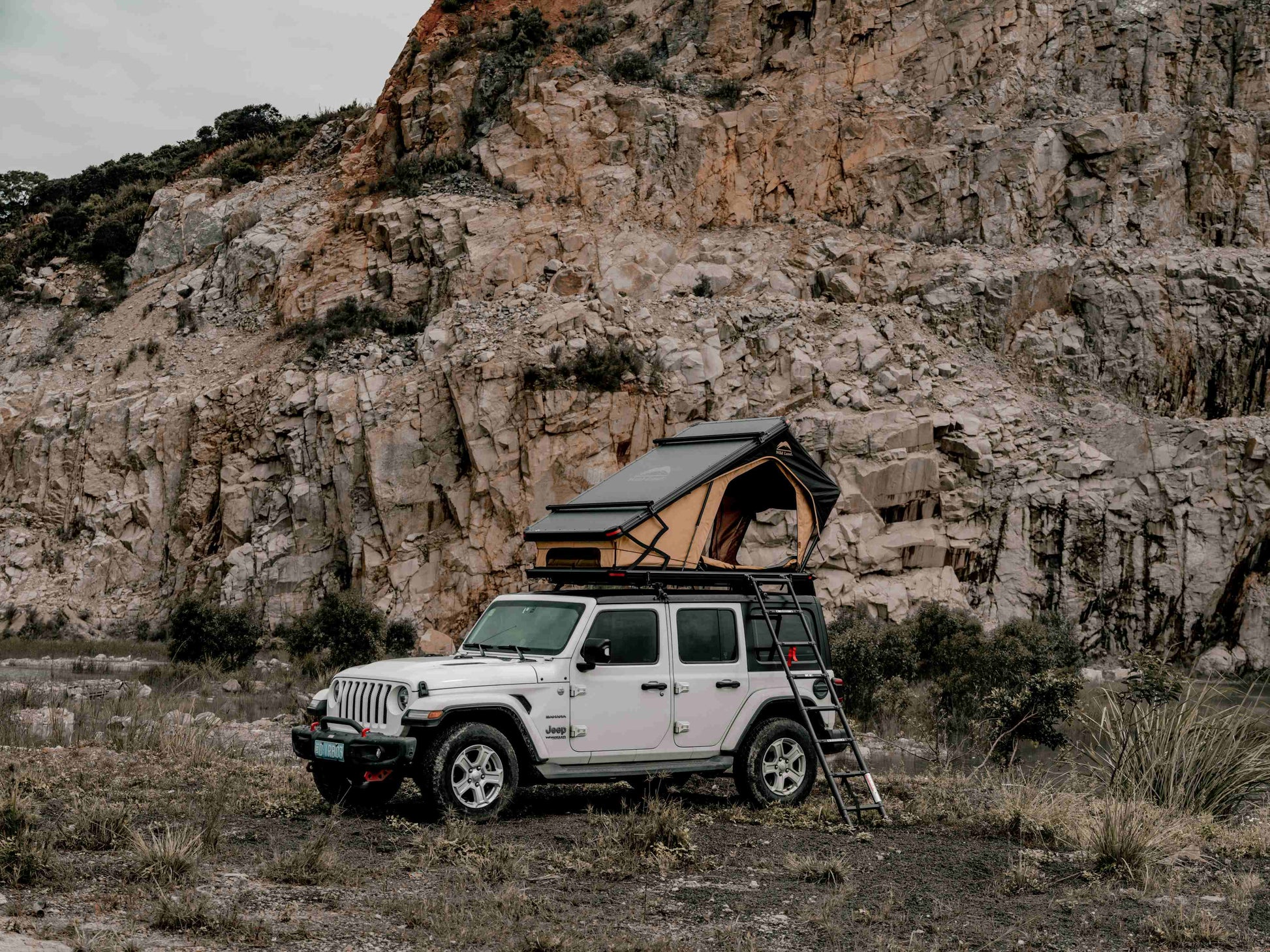 Ein auf dem Jeep aufgebautes Dachzelt vor einer Felswand