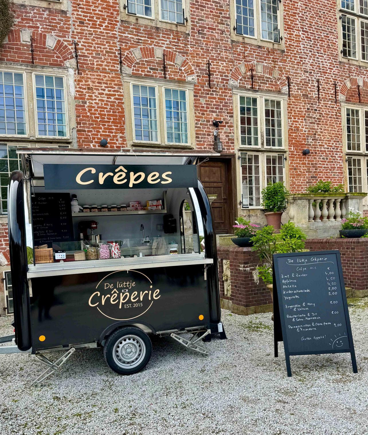 Ein Foodtrailer der Crepes vor einer schoenen historischen Kulisse anbietet