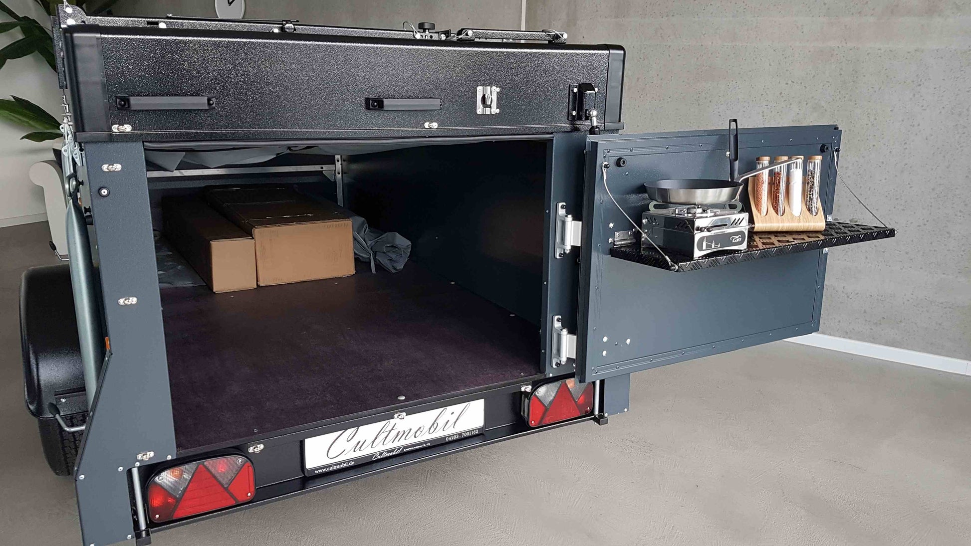 Faltcaravan mit geöffneter Heckklappe und sichtbarem Staurraum