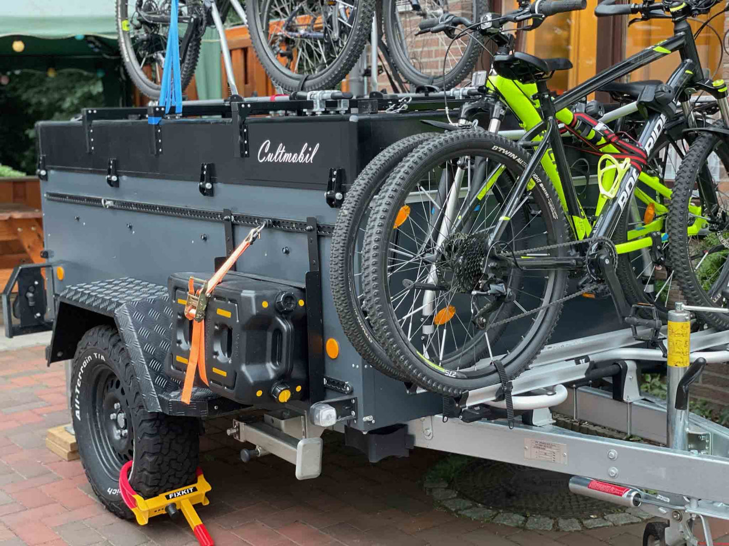 Klappcamper Offroad mit vollständig auf und angebautem Zubehör. Zu sehen sind Fahrräder, Wassertank Befestigungssysteme