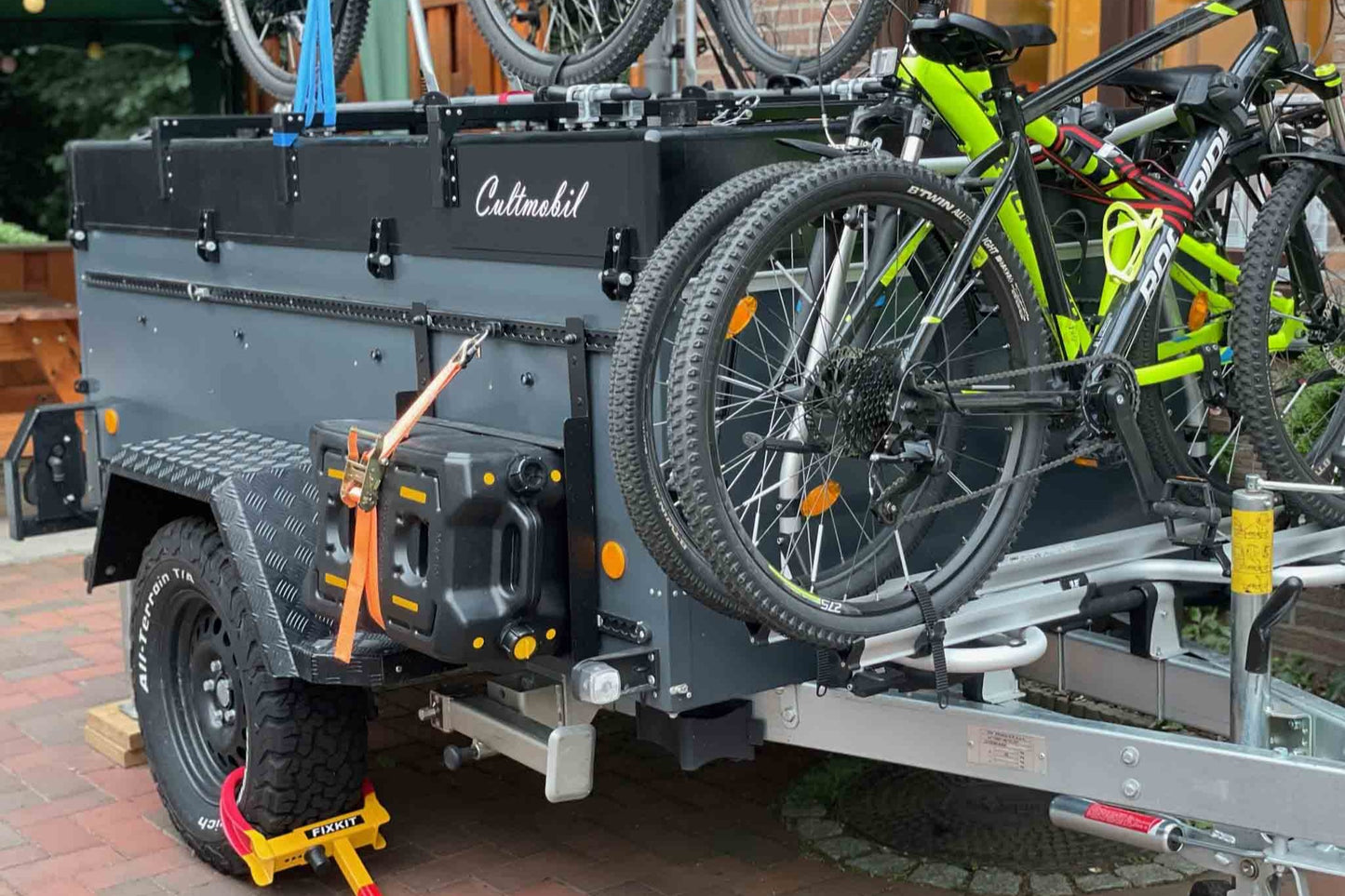 Ein Klappcamper mit viel aufgebautem Zubehör. Darunter Fahrradträger, Spritkanister und Befestigungsschiene.
