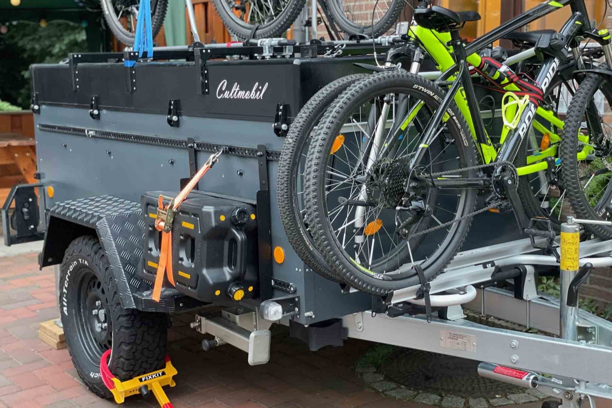 Ein Klappcamper mit viel aufgebautem Zubehör. Darunter Fahrradträger, Spritkanister und Befestigungsschiene.