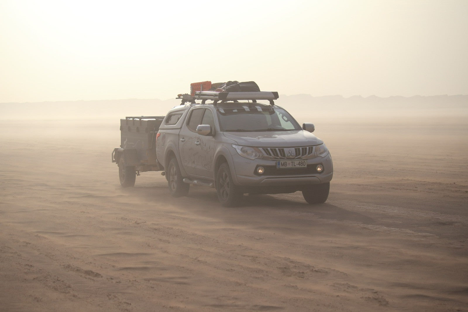 Offroad Campinganhänger in der Wüste gezogen von einem Geländewagen
