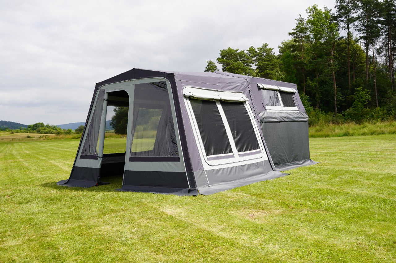 Ein augebauter Faltcaravan auf einem Golfplatz mit Vorzelt.