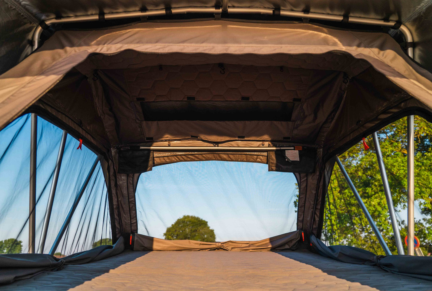 Innenansicht eines aufgeklappten Familien-Dachzelts, aufgenommen in der Natur