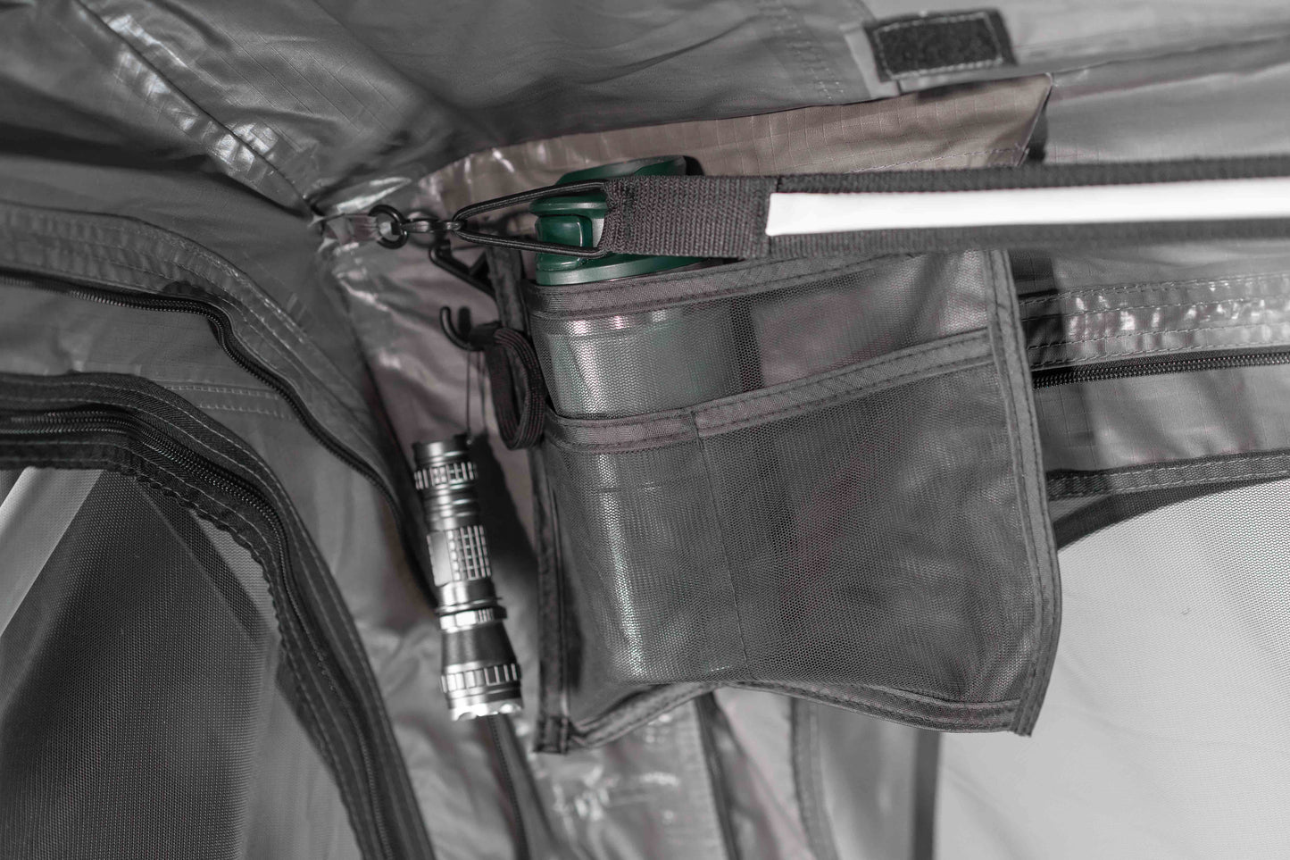 Verstaumöglichkeiten eines Dachzeltes, die eine Trinkflasche und Taschenlampe zeigen.