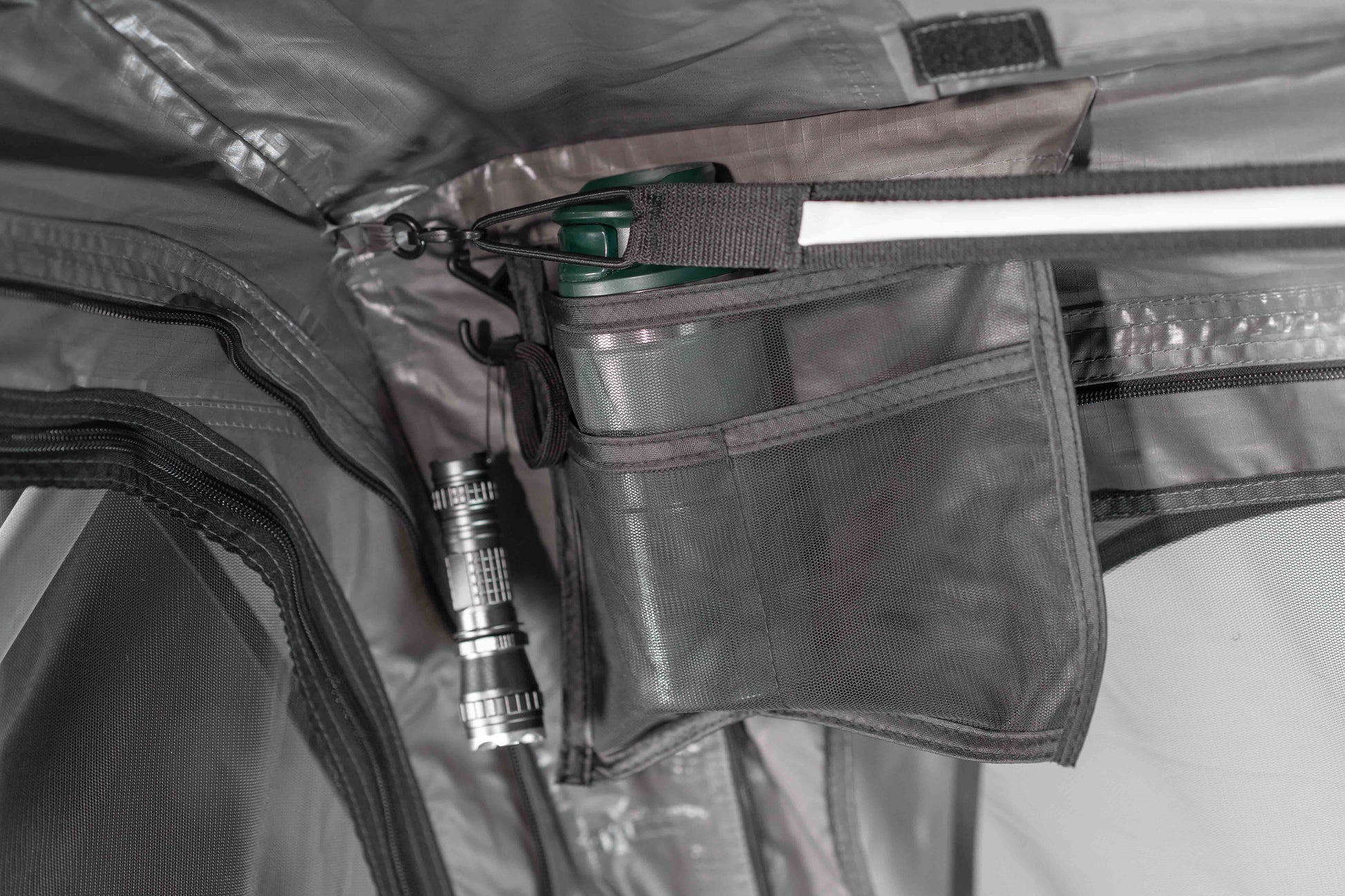 Verstaumöglichkeiten eines Dachzeltes, die eine Trinkflasche und Taschenlampe zeigen.