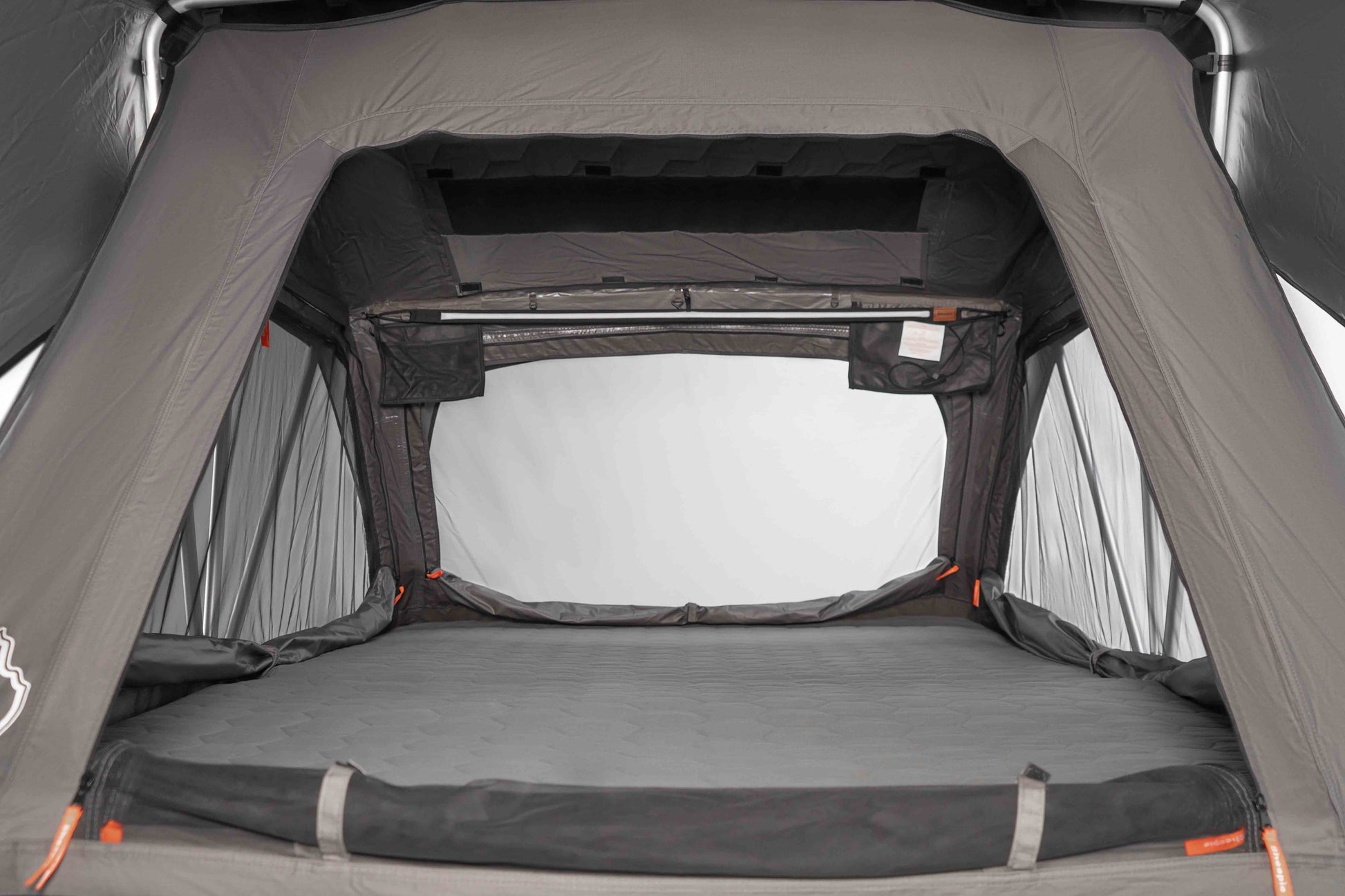 Innenansicht eines Dachzeltes mit Blick auf die Matratze, die Seitenteile und den Himmel