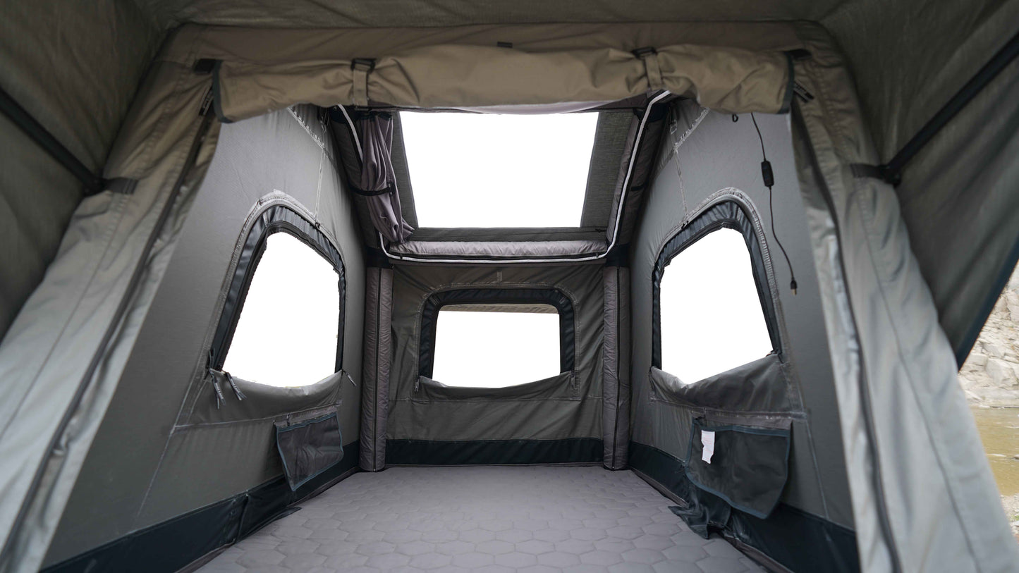 Innenansicht eines Dachzelts mit geöffneten Seitenteilen und sichtbarem Zelthimmel