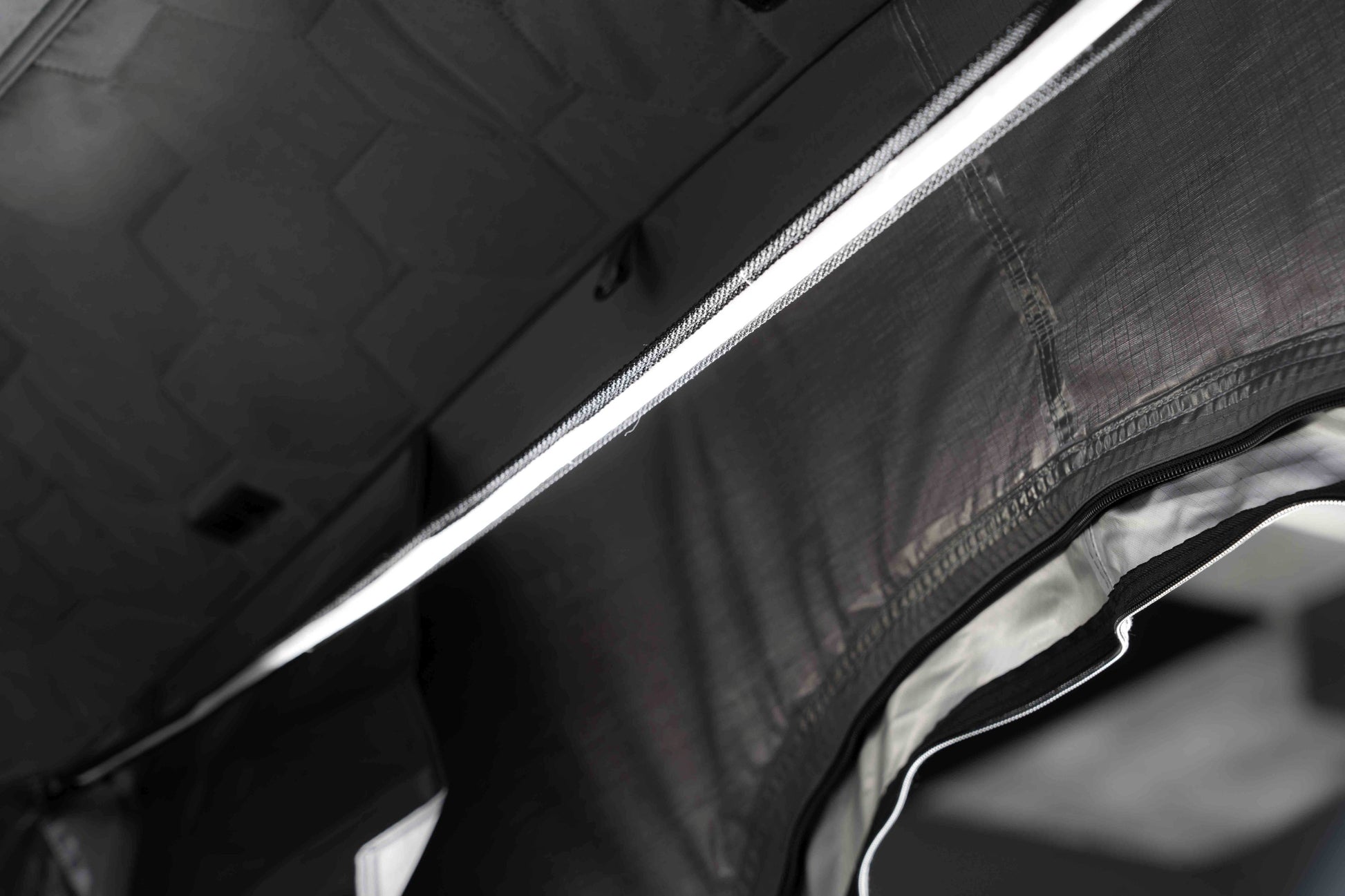 Blick ins Innere eines Dreipersonen-Dachzelts, Fokus auf das Ripstop-Gewebe der Zeltwände